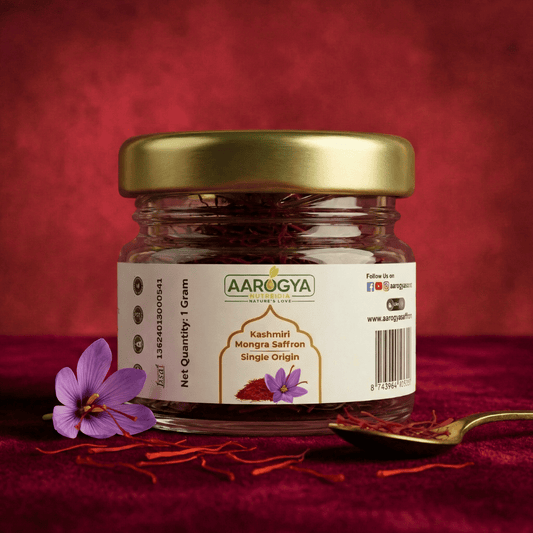 Aarogya Nutri Mix Kashmiri Mongra Saffron Single Origin 1 gram glass jar with gold lid, saffron strands and saffron flowers on red background