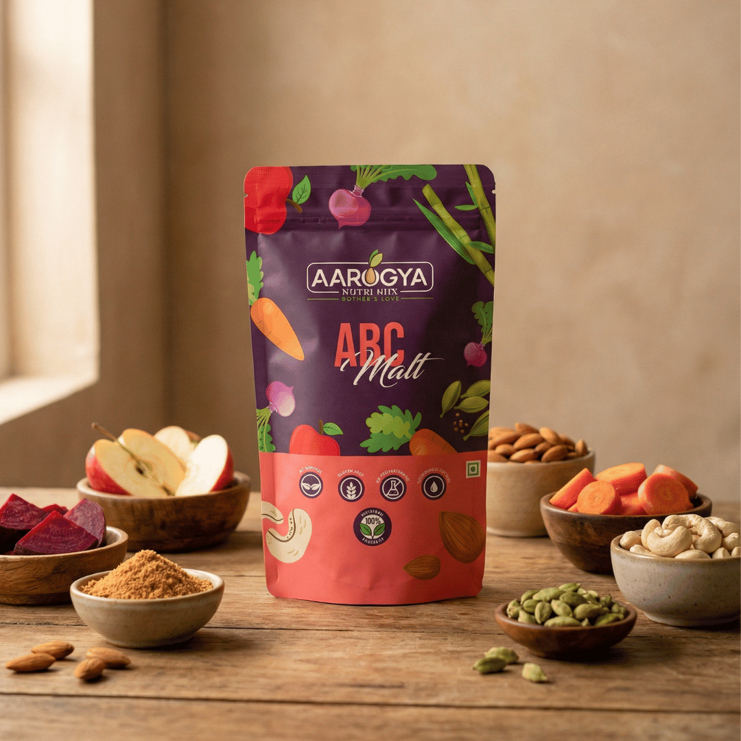 Aarogya Nutri Mix ABC Malt product pouch displayed with whole raw ingredients like sliced carrots, cardamom, and almonds.