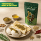 Aarogya Nutri Mix Kaaram Podi sprinkled over idli and dosa on a plate with ghee, almonds, red chilli and coriander seeds